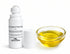 A white roll-on bottle of topical pain relief with its cap removed, shown next to a small clear glass bowl filled with yellow oil on a white background.